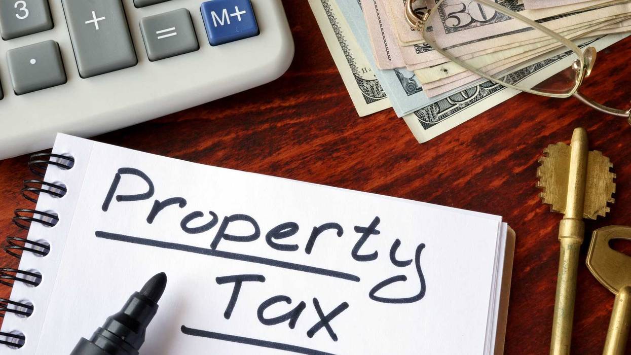 Property tax written in a notebook and calculator