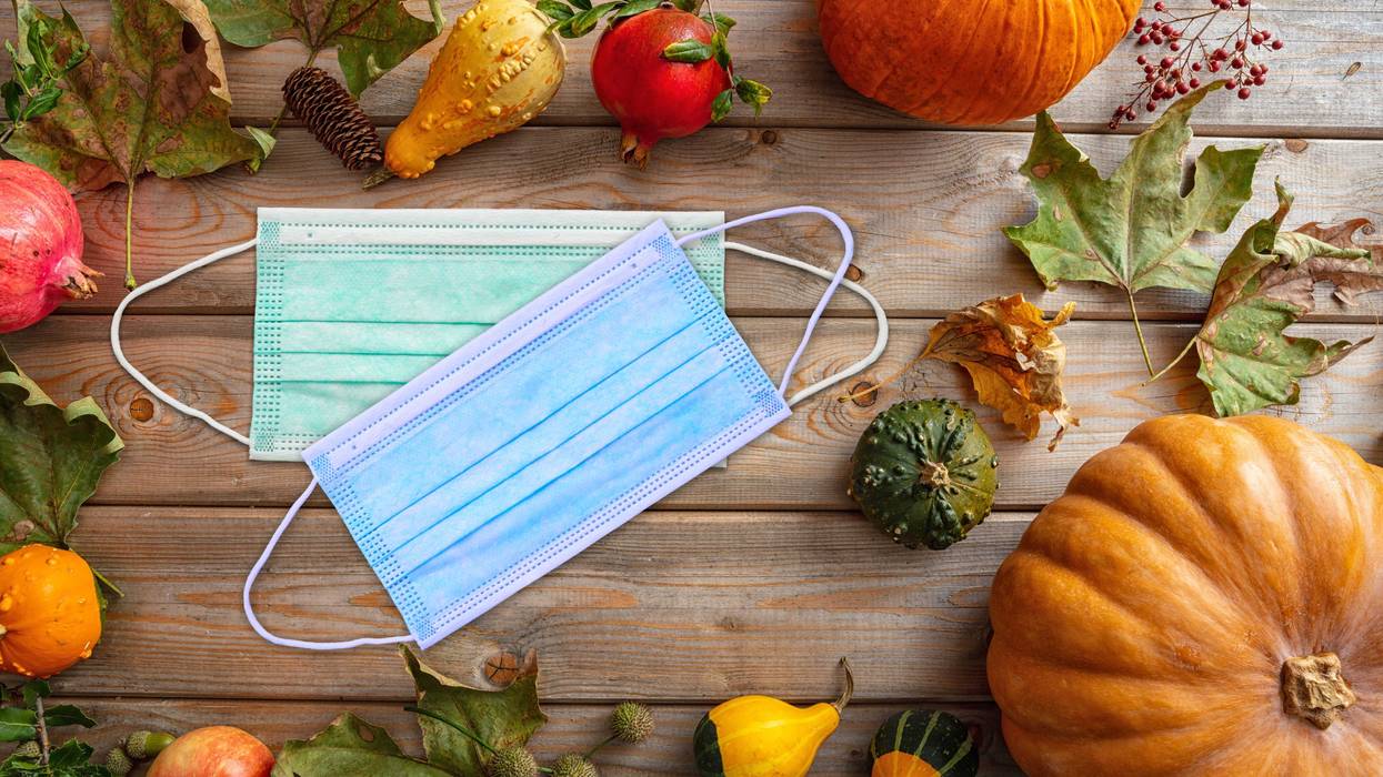 Protective mask and thanksgiving pumpkins against wooden background