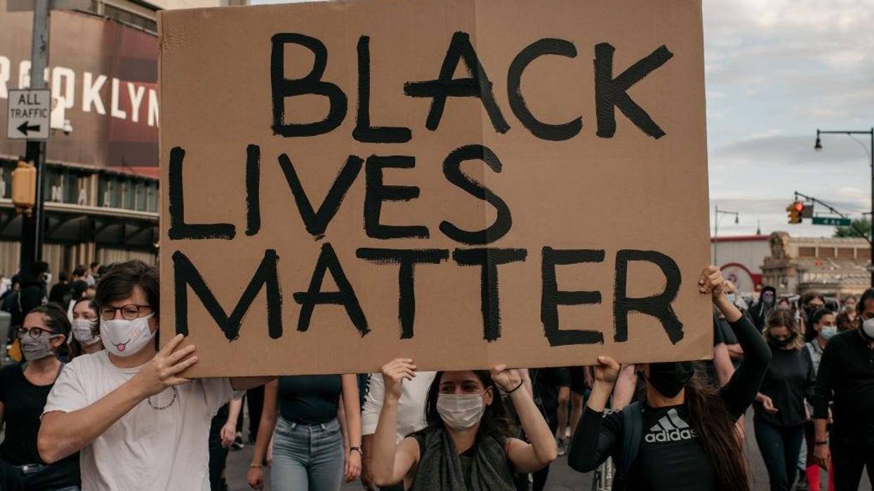 Protesters carry a Black Lives Matter sign during a march denouncing police brutality and systemic racism in the Brooklyn borough of New York City.