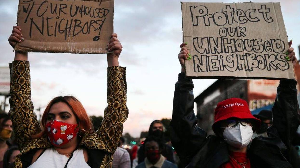: Protesters demonstrate on Sunset Boulevard against the removal of a homeless encampment at Echo Park Lake on March 25, 2021 in Los Angeles, California. People who were living in tents during the pandemic at the park were asked to leave by officials recently. The park was fenced off yesterday evening and a cleanup of the area began today. (Photo by Mario Tama/Getty Images)