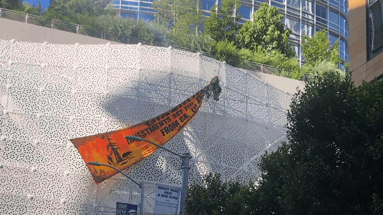 Protesters hang a banner across the side of the Salesforce Transit Center in San Francisco on Friday.