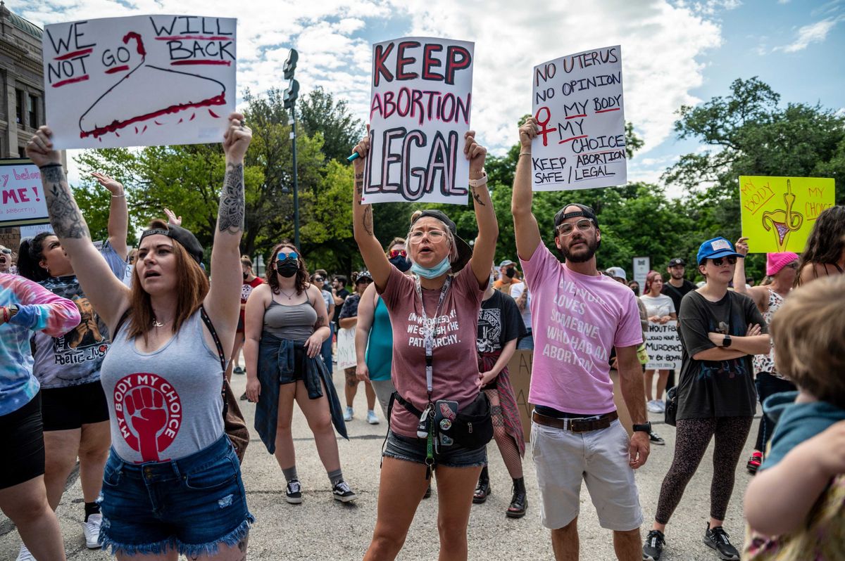Protesters hold up signs and cheer at a protest outside the Texas state capitol on May 29, 2021 in Austin, Texas.