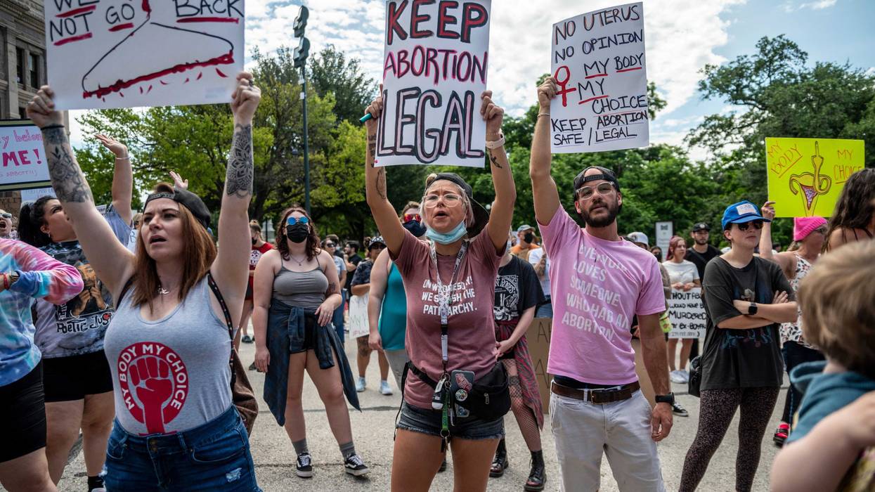 Protesters hold up signs and cheer at a protest outside the Texas state capitol on May 29, 2021 in Austin, Texas.