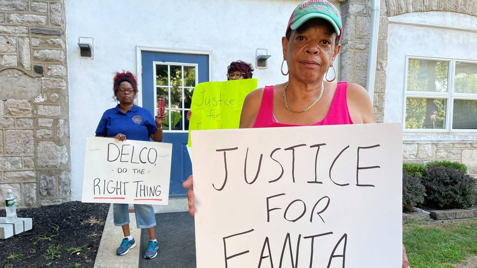 Protesters holding signs in response to the heavily-redacted report about Sharon Hill police shooting and killing Fanta Bility, 8, last year at a high school football game.