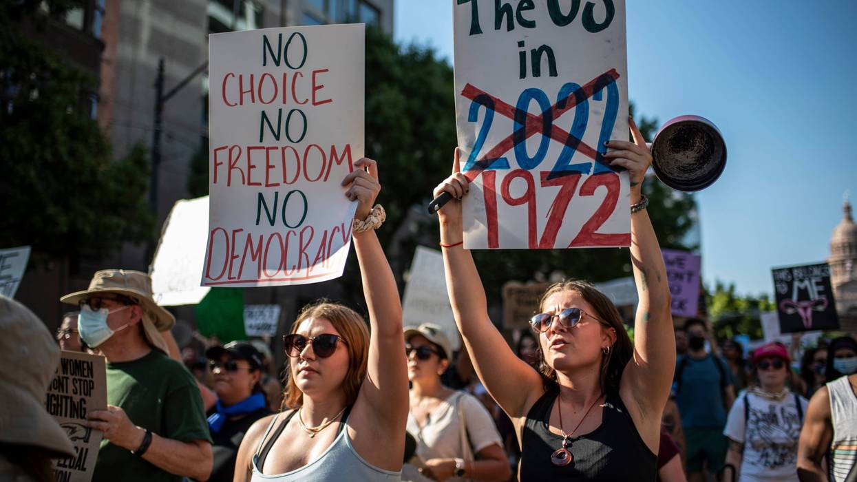 Protesters march while holding signs during an abortion-rights rally on June 25, 2022 in Austin, Texas.