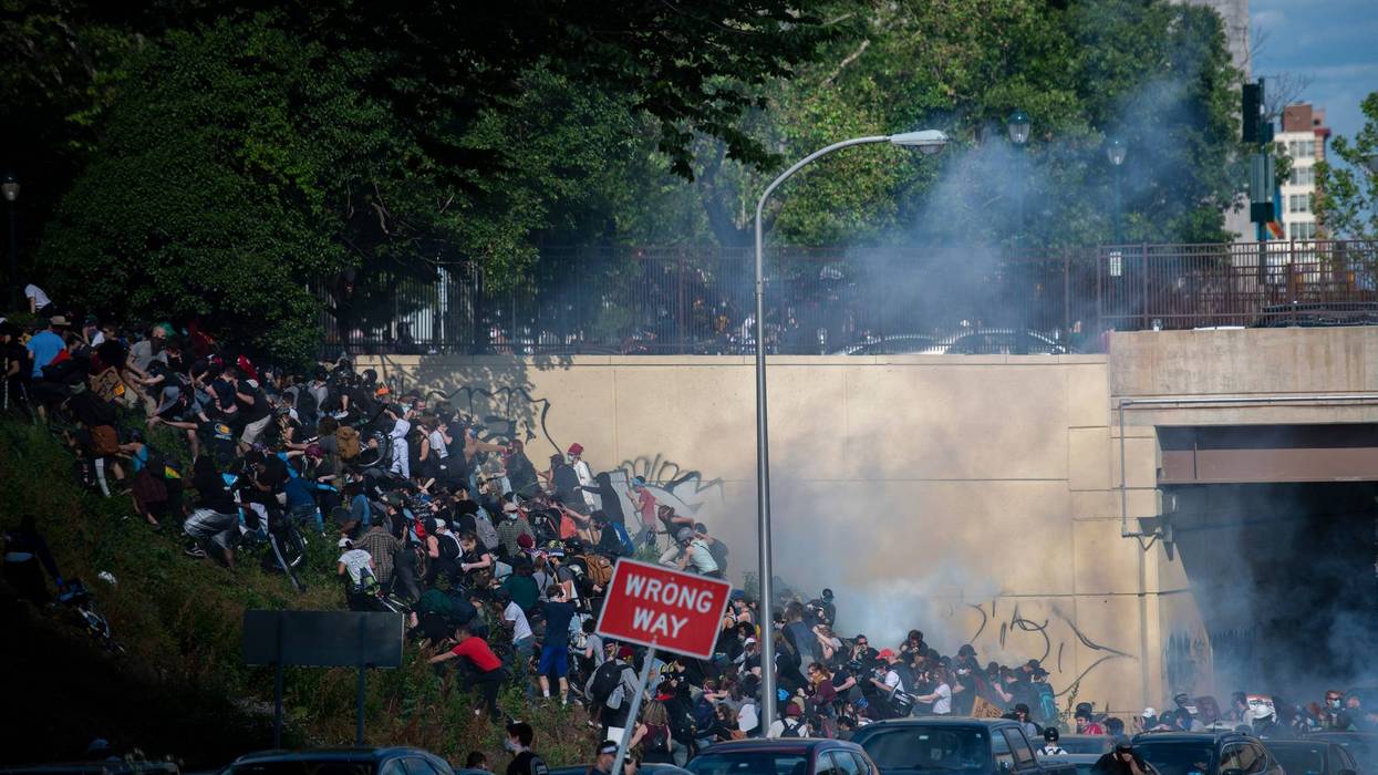 Protesters race up a hill after tear gas was deployed during a march through Center City and I-676 on June 1, 2020, in Philadelphia, Pennsylvania.