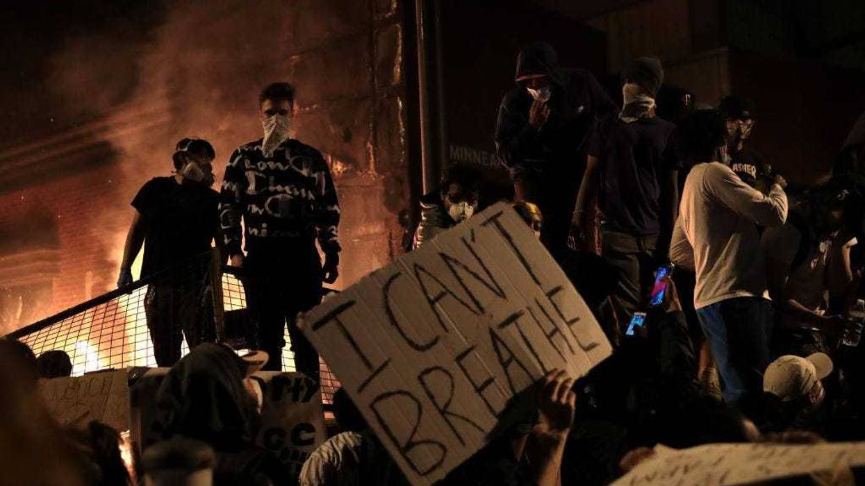 Protesters stand in front of the 3rd precinct police building as it burns during a protest on May 28, 2020 in Minneapolis, Minnesota.