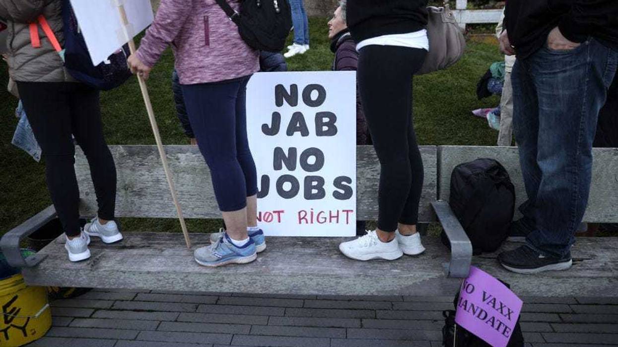 Protesters stand next to a sign during an anti-vaccination rally at the Golden Gate Bridge on November 11, 2021 in San Francisco, California. Protesters against the COVID-19 vaccination gathered at the Golden Gate Bridge to rally against vaccine mandates. (Photo by Justin Sullivan/Getty Images)