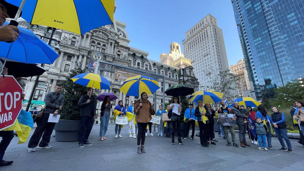 Protesters stand outside City Hall on Oct. 10, 2022, with blue and yellow umbrellas — the colors of the Ukrainian flag — to represent a symbolic shield for Ukraine as it faces airstrikes from Russia.