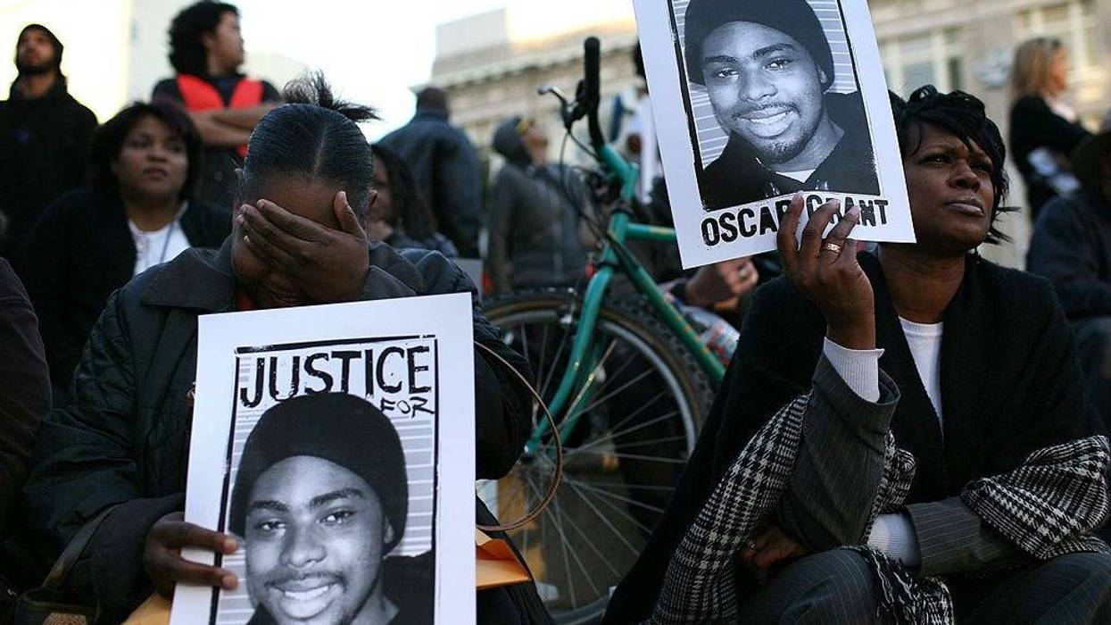 Protestors carry signs with a picture of slain 22-year-old Oscar Grant III during a demonstration at Oakland City Hall January 14, 2009 in Oakland, California.