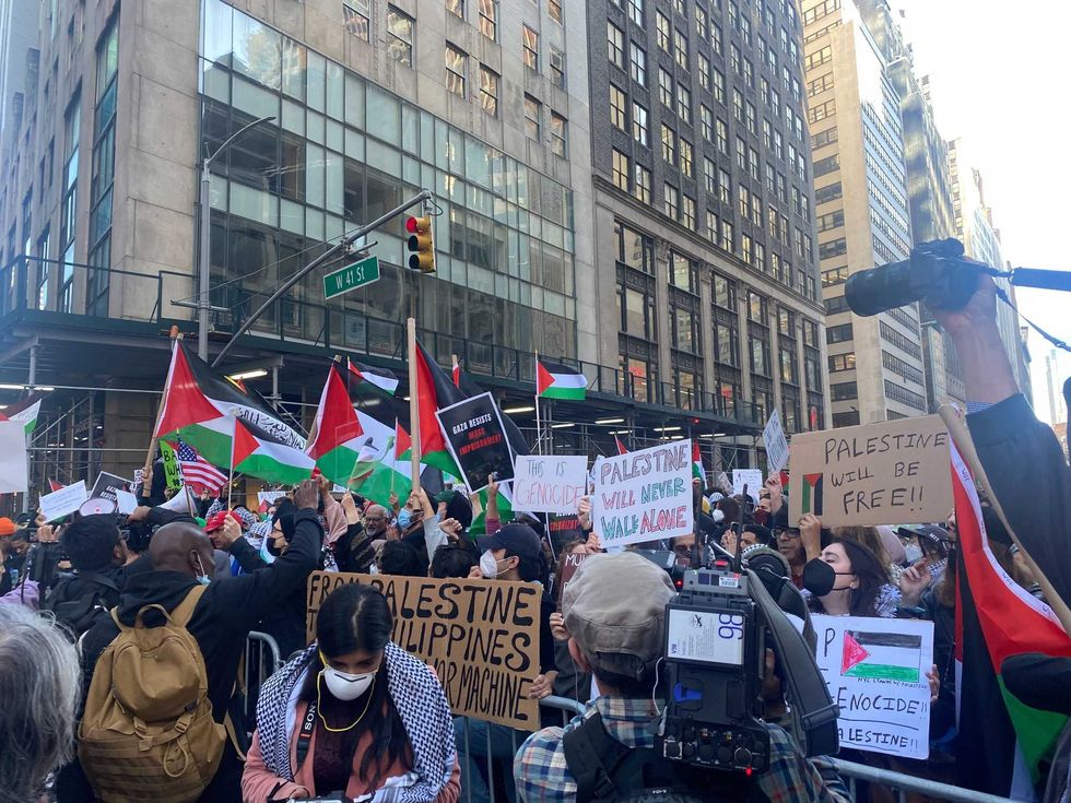 Protestors hold signs in support of Palestine.