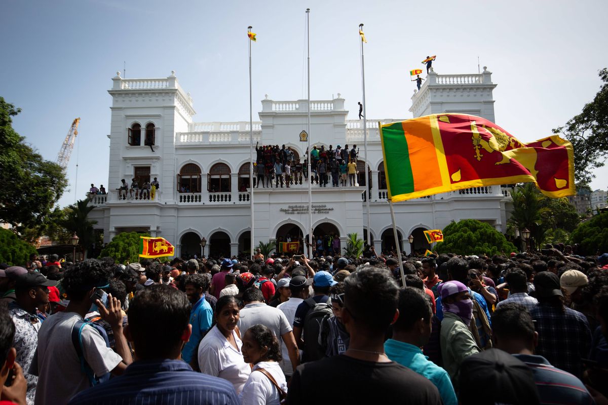 Protestors wave flags and chant slogans after taking control of the Prime Ministers office compound during a protest seeking the ouster of Sri Lanka's Prime Minister Ranil Wickremesinghe amidst the ongoing economic crisis on July 13, 2022 in Colombo, Sri Lanka.