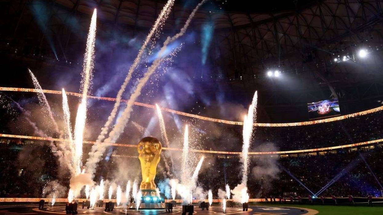 Pyrotechnics surround a giant FIFA World Cup trophy prior to the FIFA World Cup