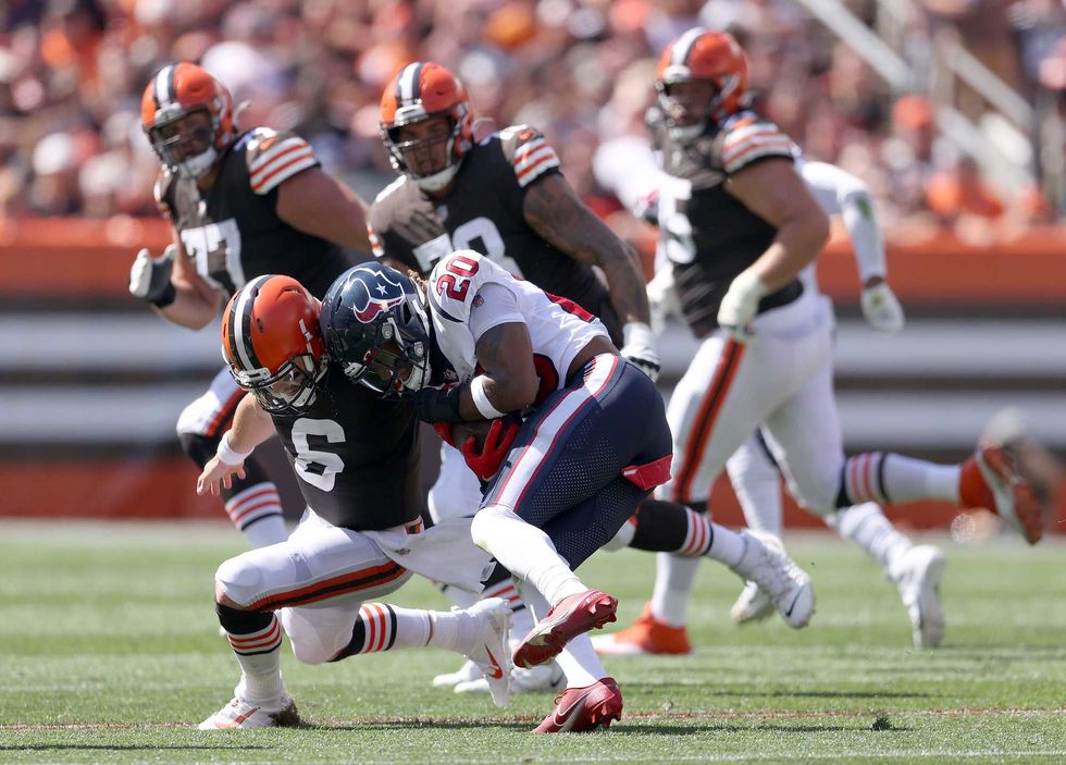 Quarterback Baker Mayfield of the Cleveland Browns is hit by strong safety Justin Reid of the Houston Texan