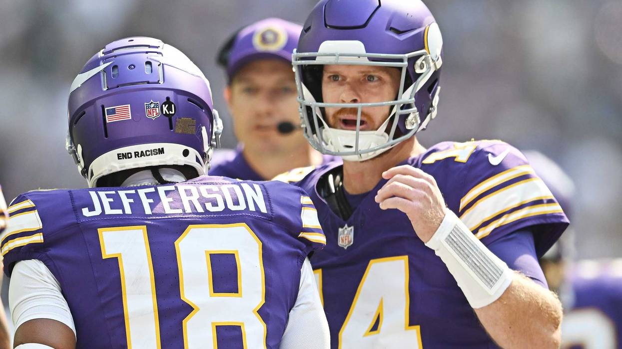 Quarterback Sam Darnold #14 and Justin Jefferson #18 of the Minnesota Vikings celebrate after their touchdown connection against the Houston Texans during the first quarter at U.S. Bank Stadium on September 22, 2024 in Minneapolis, Minnesota.