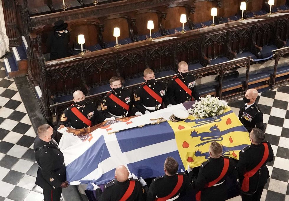 Queen Elizabeth II watches as the coffin of the Duke of Edinburgh is placed St George