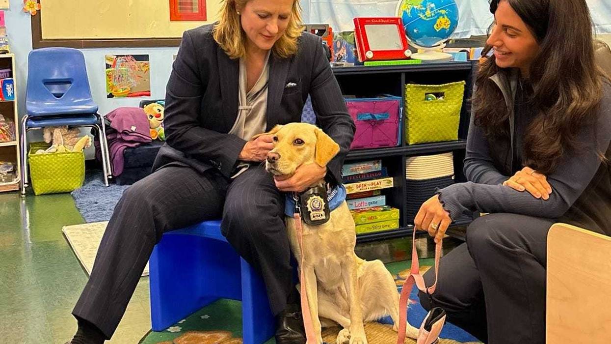 Queens District Attorney Melinda Katz (L) with Kimi, a trained facility dog who will provide comfort to special victims and victims of domestic violence at the office.