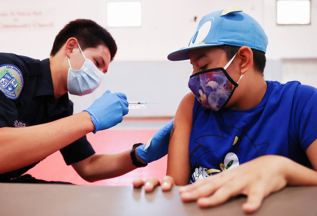 Quentin Scarborough administers a vaccine dose to student Nathan Alex Perez during a pop-up COVID-19 vaccination clinic at James Jordan Middle School on July 6, 2021 in Winnetka, California.
