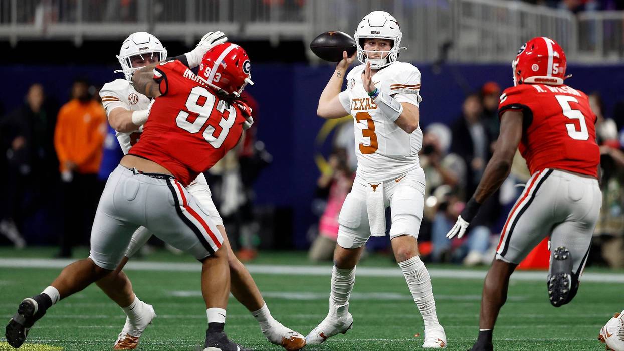 Quinn Ewers #3 of the Texas Longhorns looks to pass the ball under pressure against Tyrion Ingram-Dawkins #93 and Raylen Wilson #5 of the Georgia Bulldogs during the second quarter of the 2024 SEC Championship at Mercedes-Benz Stadium on Dec. 7, 2024, in Atlanta, Georgia.