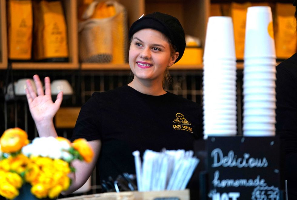Rachel waves to customers at Café Joyeux