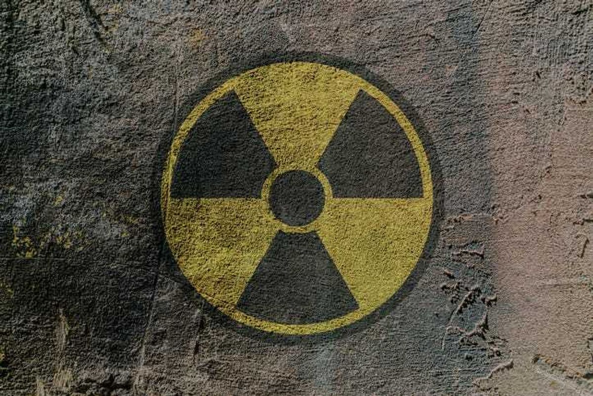 Radiation hazard warning sign depicted on a concrete wall.