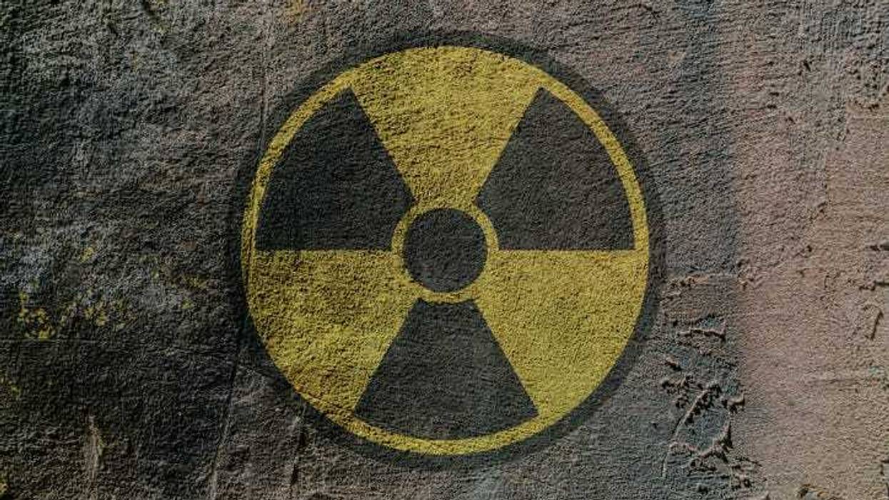 Radiation hazard warning sign depicted on a concrete wall.