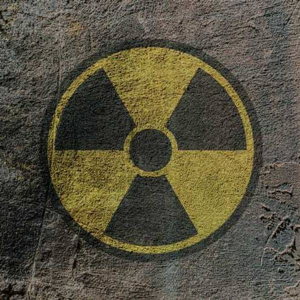 Radiation hazard warning sign depicted on a concrete wall.