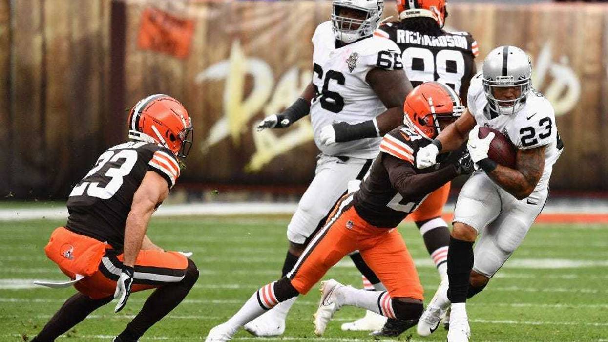 Raiders running back Devontae Booker rushes the football past Browns cornerback Denzel Ward