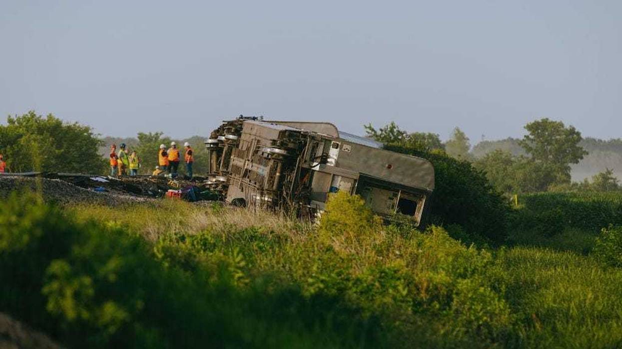 Railroad workers work the scene where an Amtrak train derailed on June 27, 2022 in Mendon, Missouri.