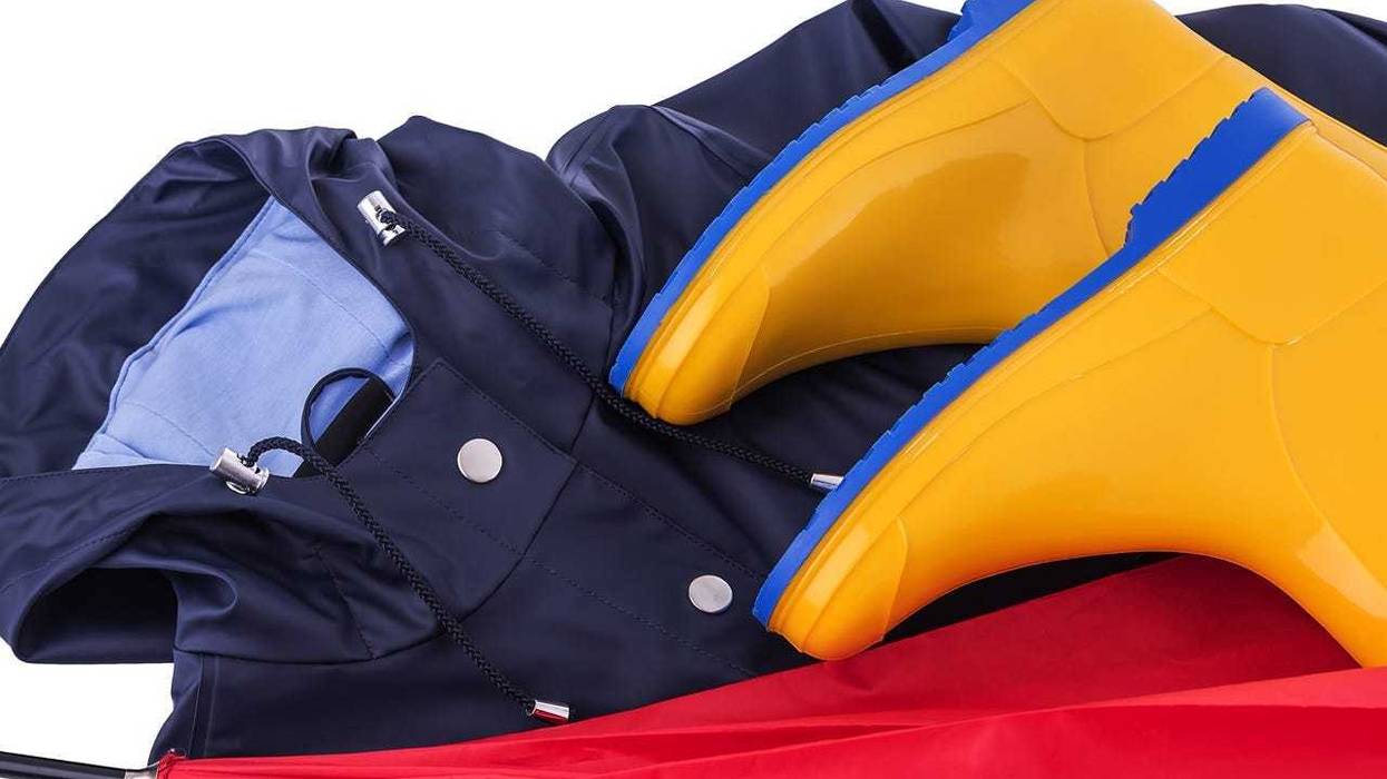 Rain gear Raincoat and umbrella and rubber boots on a white background. Protective, footwear. (Photo credit: Tetiana Rozhnovska/Dreamstime)