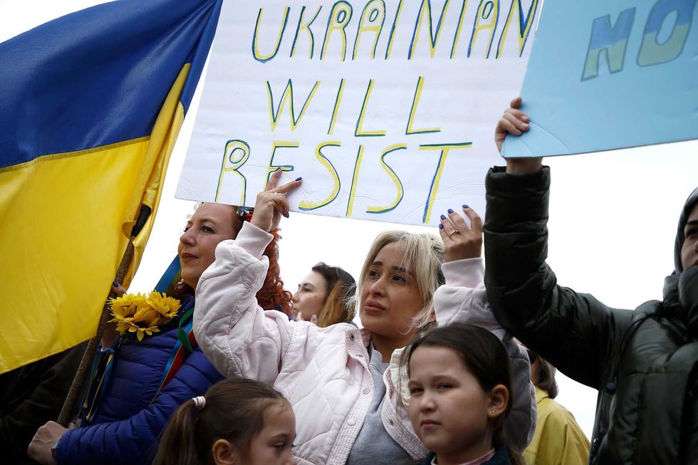 Rally participants listen to mostly Russian speakers denounce the war in the Ukraine on March 20, 2022 in the Brighton Beach section of the Brooklyn borough of New York City. As the Russian invasion of Ukraine escalates with intense shelling and targeting of civilians, many Russians have fled to neighboring countries for fear of political retribution and as a way to protest the war.