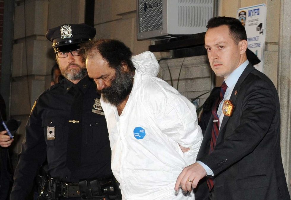 Ramon Rivera, 51, having been charged with three stabbing murders, is pictured in police custody leaving the NYPD