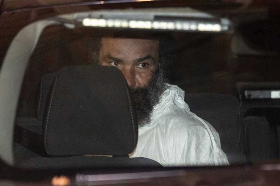 Ramon Rivera, a suspect arrested after multiple people were stabbed early Monday, is escorted out by NYPD officers at the NYPD 10th Precinct in New York, Monday, Nov. 18, 2024.