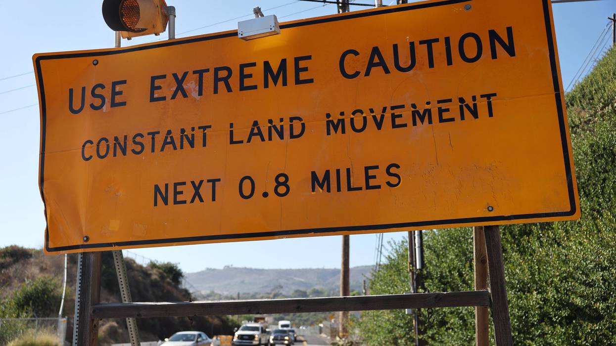 RANCHO PALOS VERDES, CALIFORNIA - SEPTEMBER 03: Vehicles pass a road sign warning "Use Extreme Caution Constant Land Movement" on September 3, 2024 in Rancho Palos Verdes, California. California Gov. Gavin Newsom declared a state of emergency today amid an ongoing land movement crisis in the area. Southern California Edison (SCE) cut off power to more than 200 homes in the area today and advised some residents to prepare to evacuate on short notice. A complex of landslides in the area, connected to ongoing ancient landslides, have accelerated following heavy rains in 2023, damaging homes and roadways.