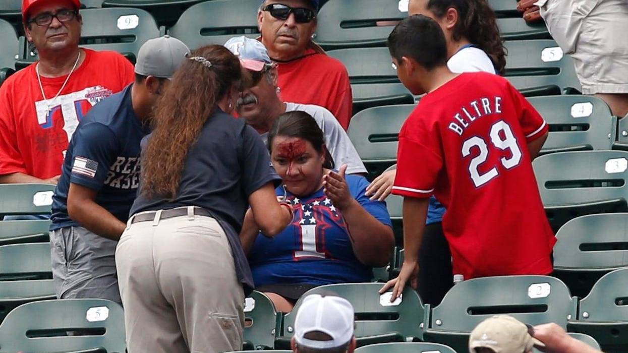 Rangers fans is attended to after being hit in the head with a ball