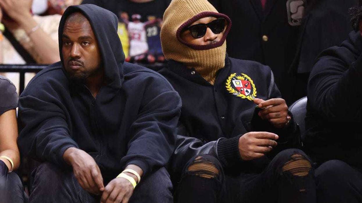 Rappers Kanye West (L) and Future look on courtside during the first half between the Miami Heat and the Minnesota Timberwolves at FTX Arena on March 12, 2022 in Miami, Florida.