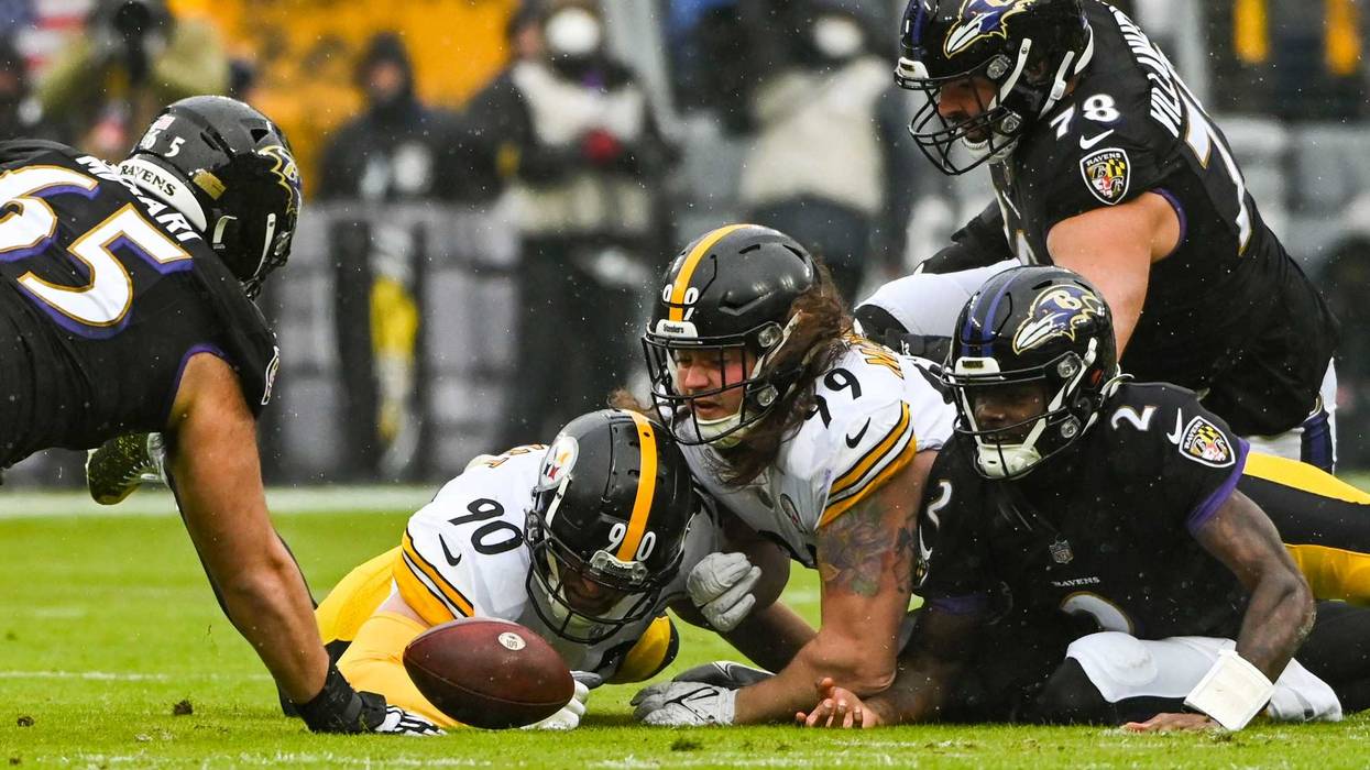 Ravens and Steelers players look at a fumble in the 1st quarter of last week's game
