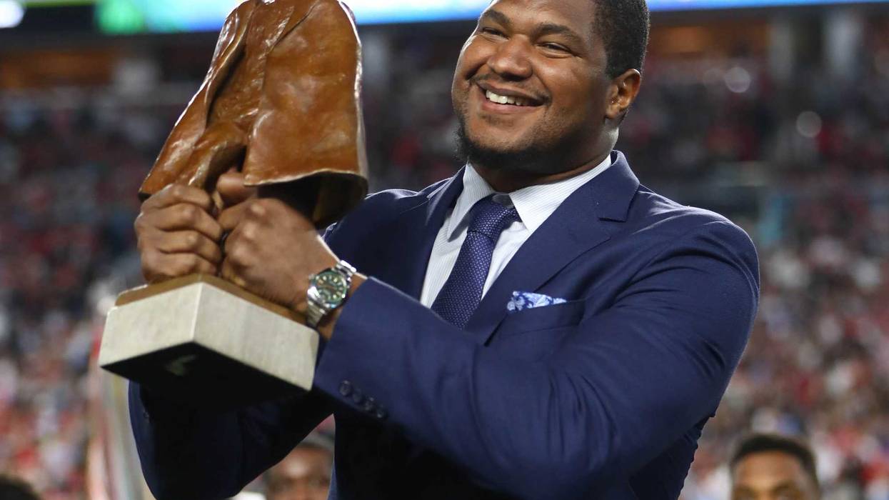 Ravens D-lineman holds up the Walter Payton Man of the Year Award during Super Bowl LIV