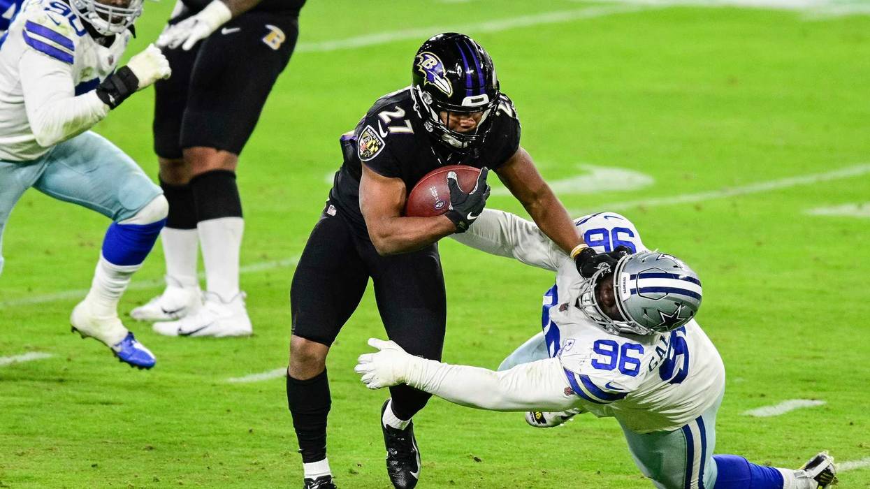 Ravens RB JK Dobbins stiff-arms Neville Gallimore during Tuesday night's Ravens victory over Dallas