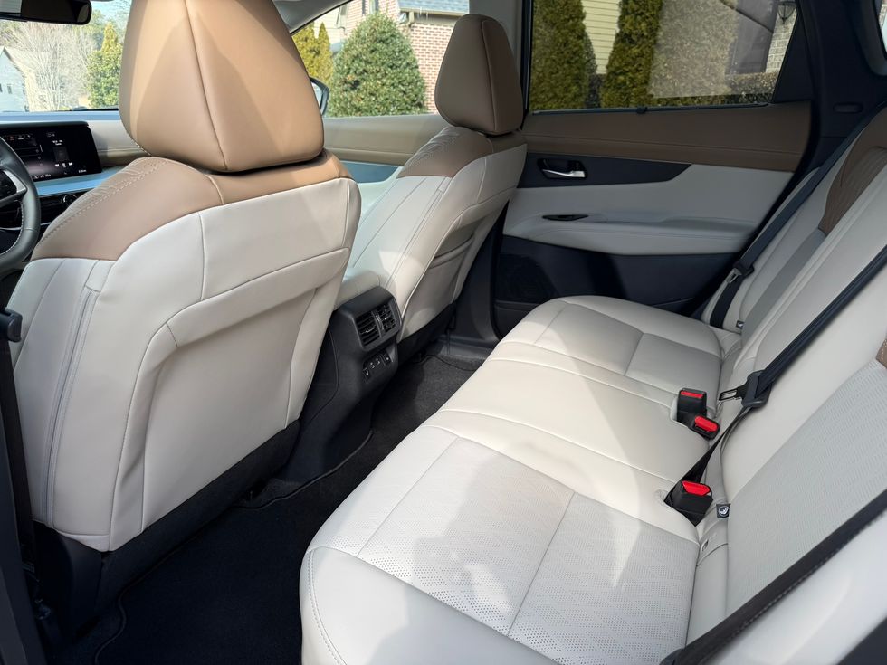 Rear passenger view of car interior with two-tone tan and cream leather seats.