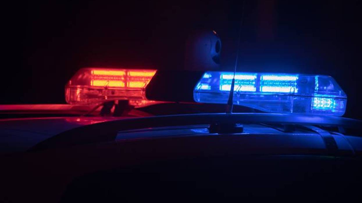 Red and blue flashing police lights on a vehicle at night.