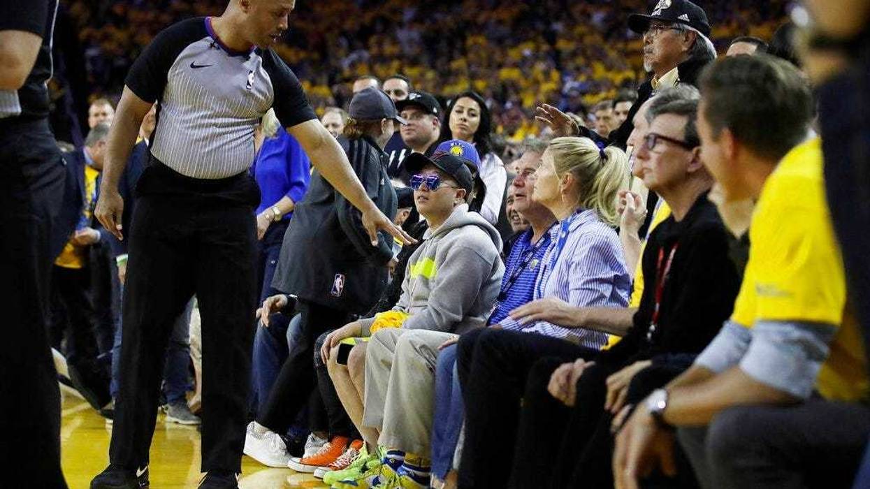 referee Marc Davis, left, gestures toward Golden State Warriors investor Mark Stevens