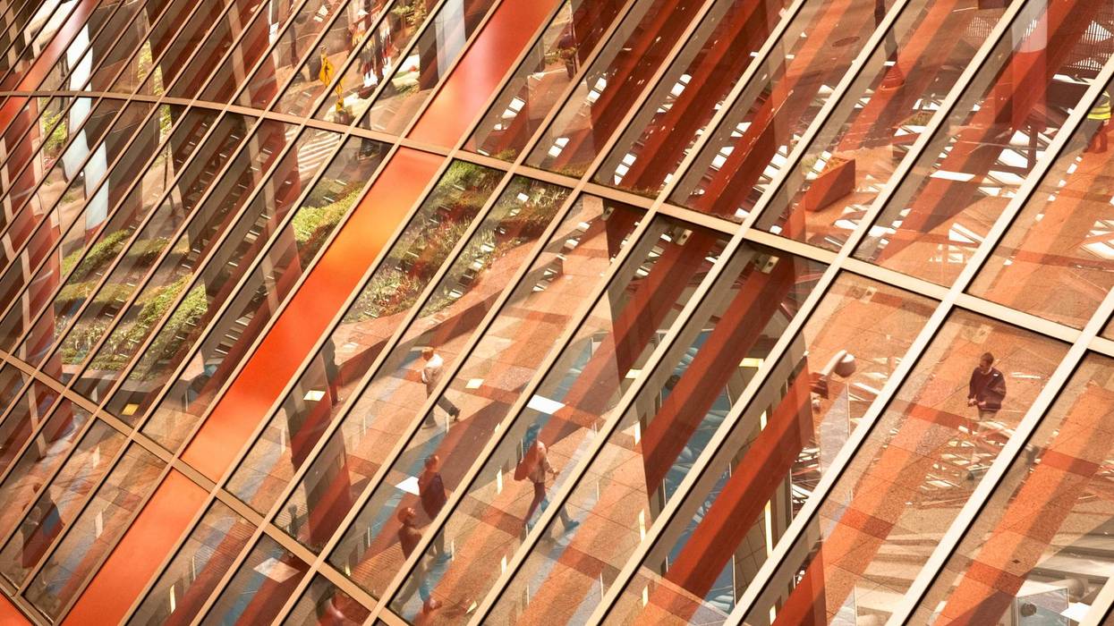 Reflection off the Thompson Center facade showing foot traffic in the street.