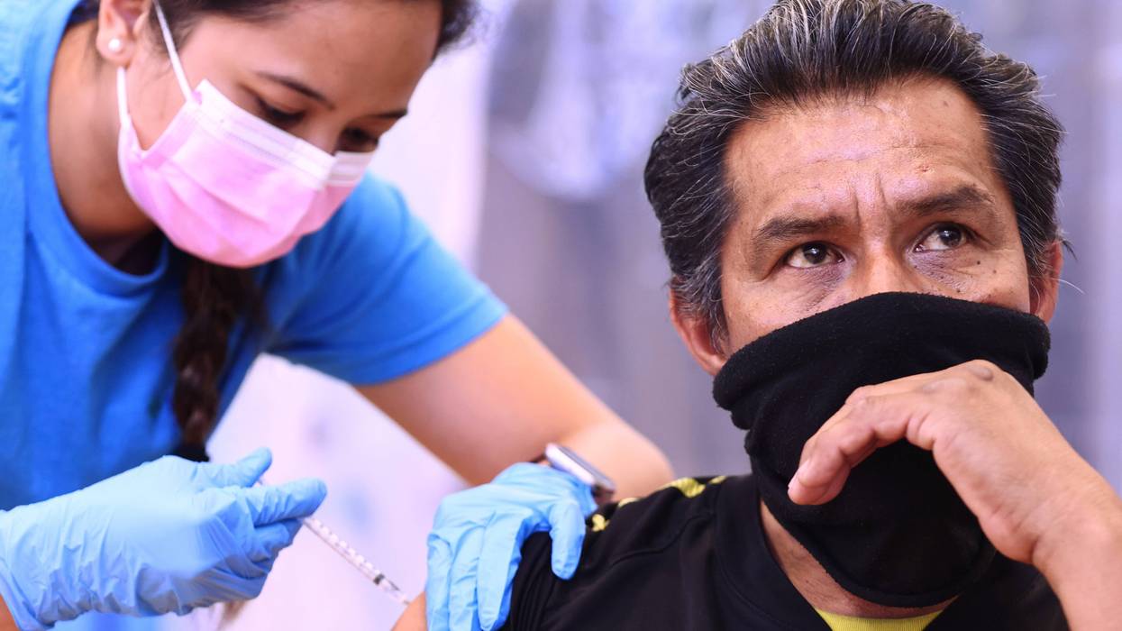 Registered nurse Darryl Hana administering a dose of the Pfizer COVID-19 vaccine to a person at a three-day vaccination clinic at Providence Wilmington Wellness and Activity Center on July 29, 2021 in Wilmington, California.