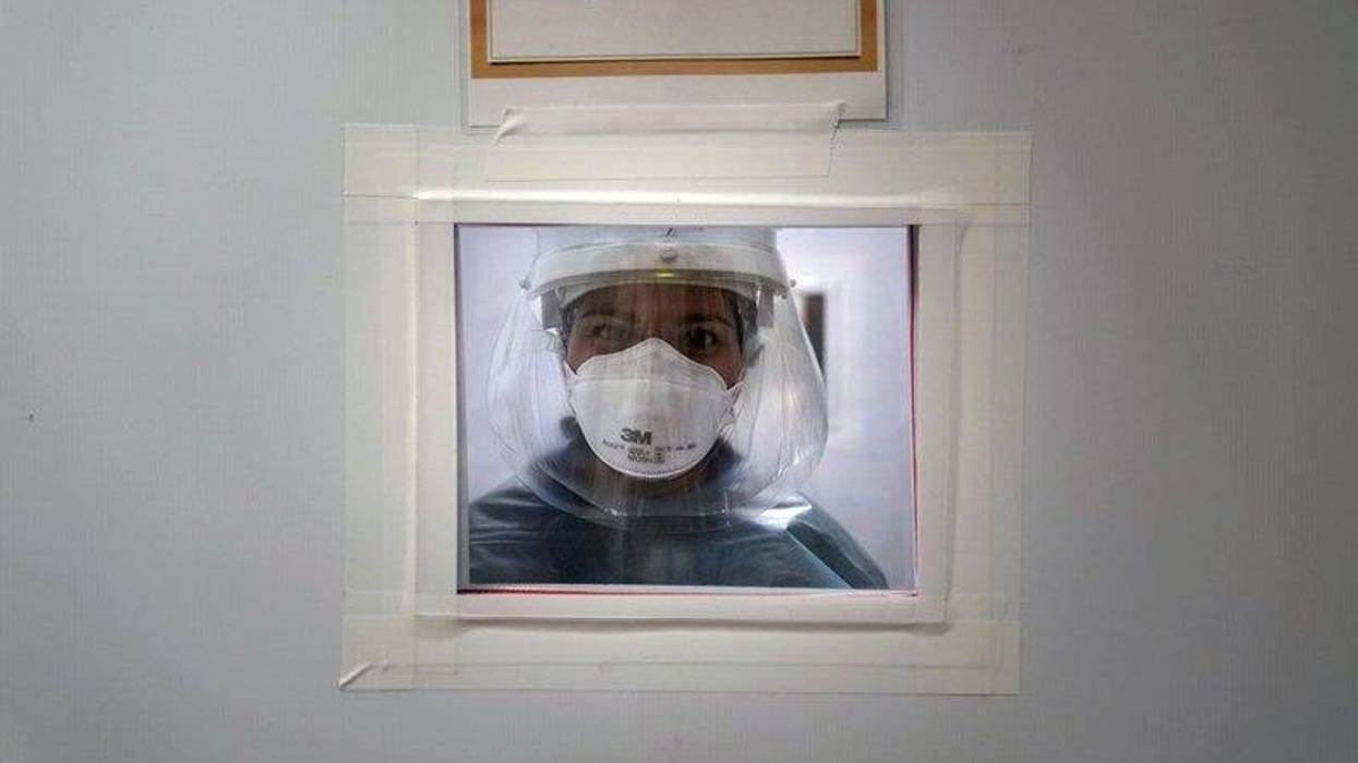 Registered nurse Nicole Grecco looks through a small window while working in a COVID-19 unit at Mission Hospital in Mission Viejo, Calif., Monday, Dec. 21, 2020.