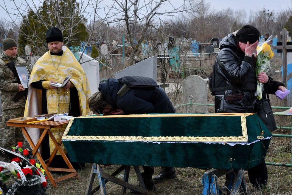 Relatives and friends cry near the coffin of Ukrainian serviceman Anatoly German during a funeral ceremony in Kramatorsk, Ukraine, Tuesday, April 5, 2022