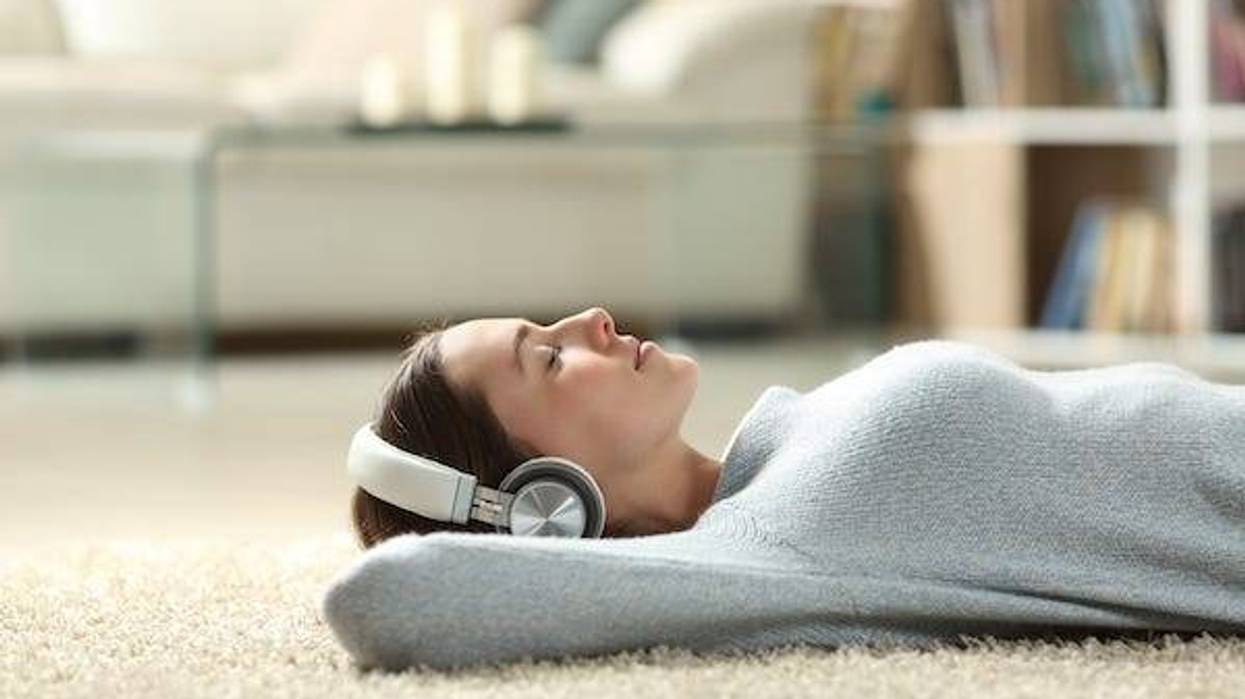 Relaxed woman listening to music with headphones at home