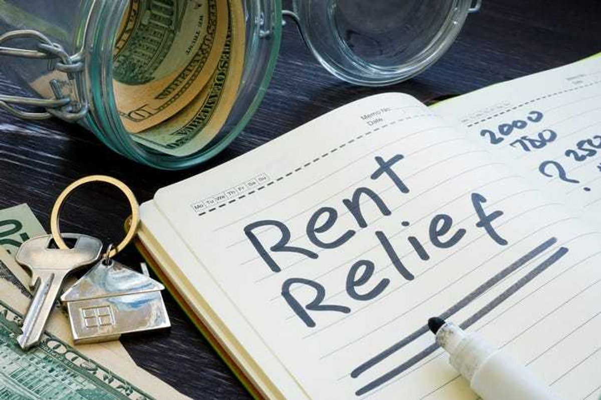 Rent relief sign and almost empty jar with money.
