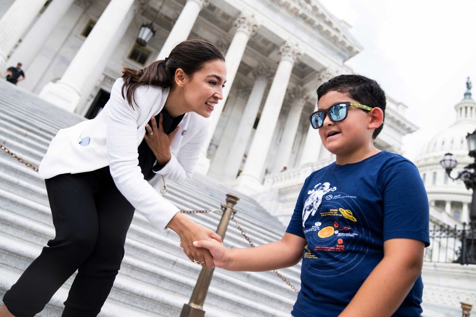 Rep. Alexandria Ocasio-Cortez, D-N.Y., greet Mariano, 8, on the House steps of the U.S. Capitol during the last votes of the week on Thursday, June 16, 2022