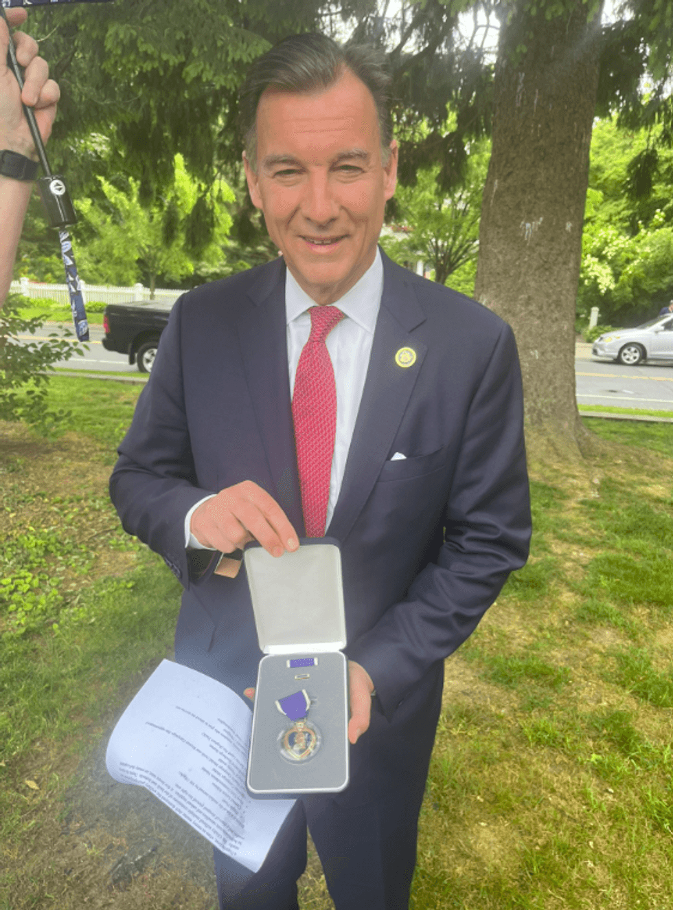 Rep. Tom Suozzi holding the Purple Heart he awarded to the Olitsky family in honor of the late William Olitsky, a Long Island WWII veteran.